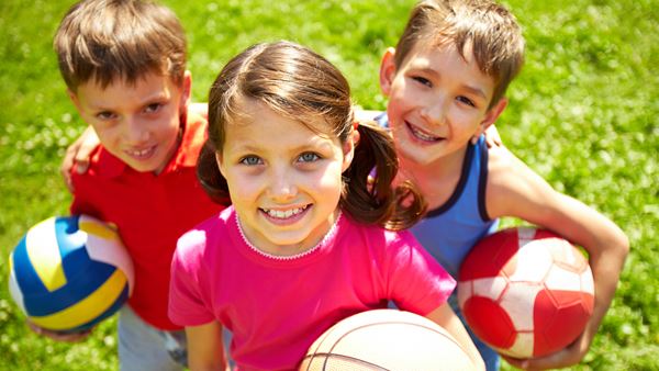 Kinderen met volleybal, basketbal en voetbal