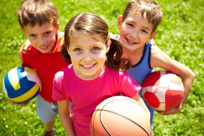 Kinderen met volleybal, basketbal en voetbal